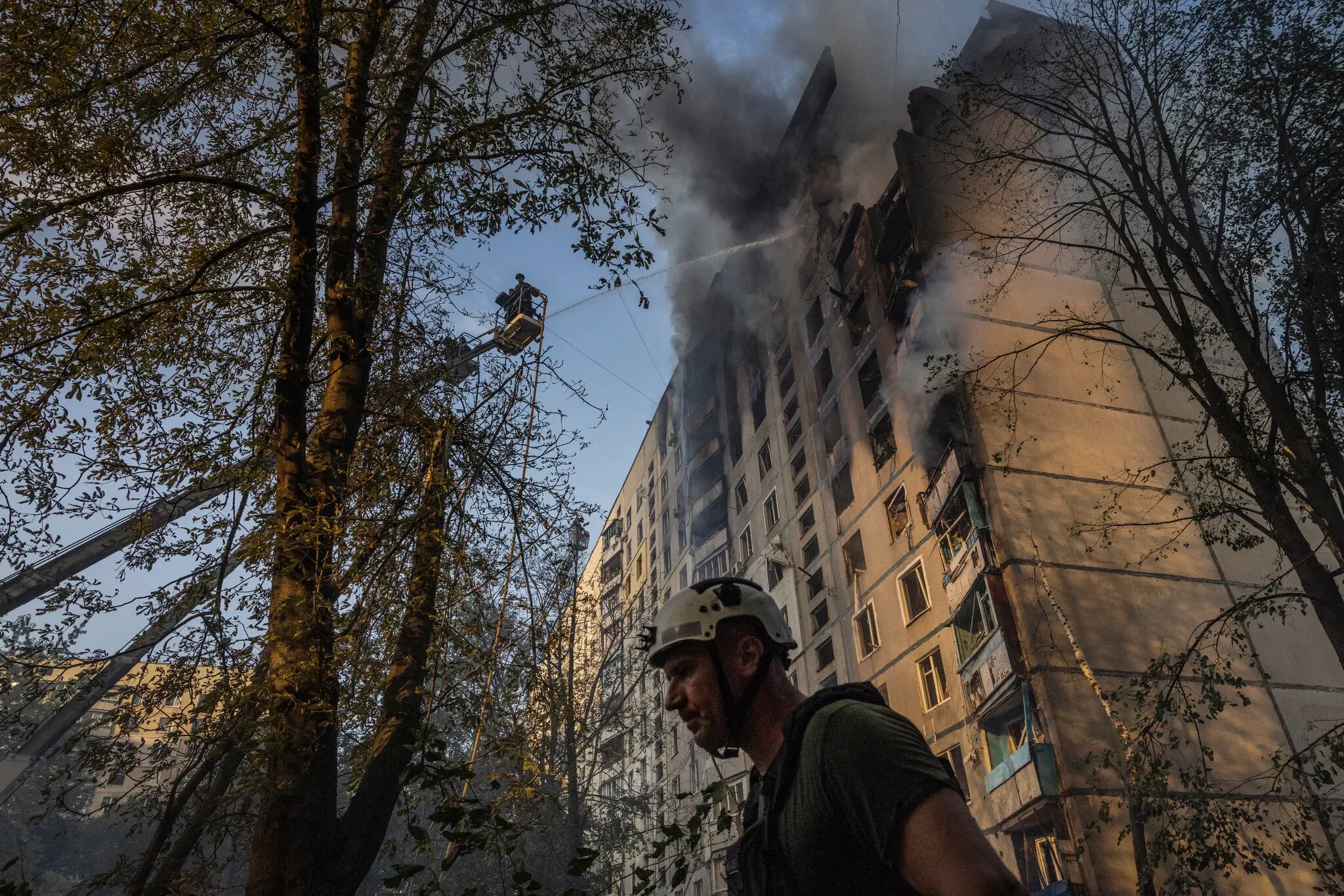 Українські пожежники борються з вогнем у житловому будинку після російського бомбардування в Харкові, Україна, у серпні.